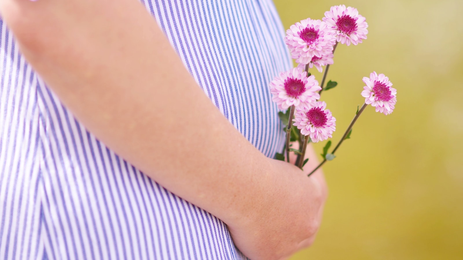 Une femme enceinte souriante, tenant son ventre rond et rayonnant de bonheur