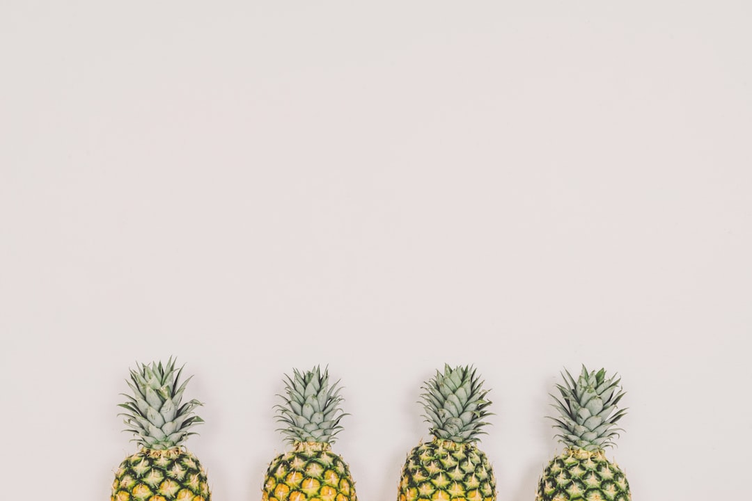 4 pineapples against a white wall