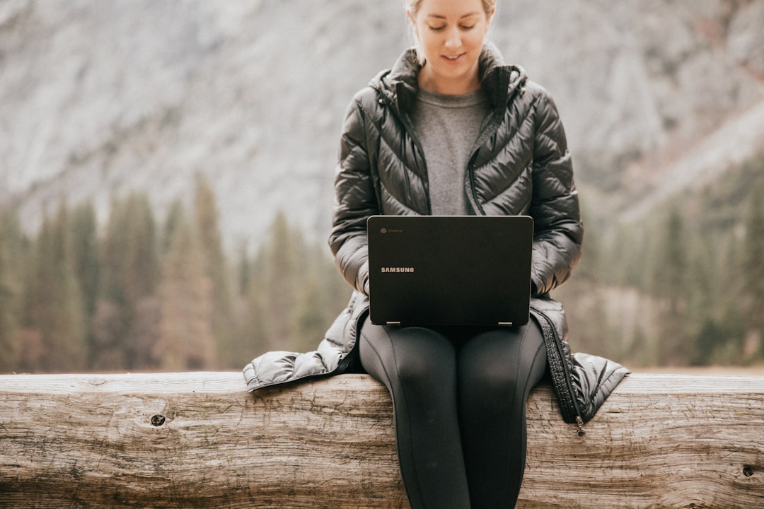 A woman doing online therapy outdoors on her laptop
