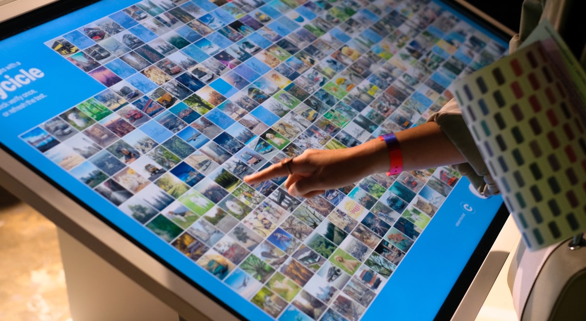 a person pointing at a large display of pictures