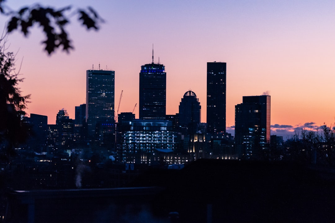 The Boston skyline, almost silhouette-lit with a pink and dusty blue sky, as if before hardly anyone has woken up