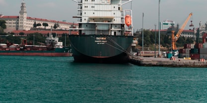 A large air freight container on a flat cart pulled by a tug.