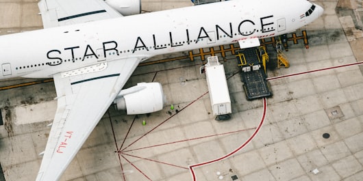 A UPS plane's tail at an airport with air cargo below to illustrate an article about cybersecurity reporting requirements for the rail and air sectors.