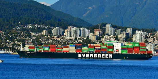 A truck a the Port of Vancouver passes a train with containers.